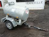 a trailer with a tank attached to it in front of a building