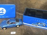 une boîte en fer-blanc bleue contenant une petite voiture et une boîte en fer-blanc bleue contenant une petite voiture
