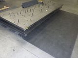 une photo d'une table parsemée de clous dans un entrepôt