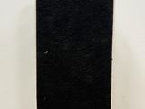 a close up of a black and white speaker on a wooden table
