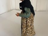 a figurine of a woman in a dress and hat