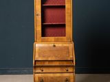 an old wooden bureau with a red velvet cover on top