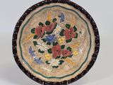 une image représentant une assiette décorative ornée de fleurs et de feuilles