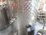 deux grandes cuves en acier inoxydable posées sur un sol carrelé