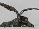 une sculpture en bronze représentant deux oiseaux posés sur un rocher