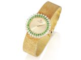 une photo d'une montre-bracelet en or sertie de pierres vertes et blanches