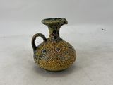 a small vase that is sitting on a white surface