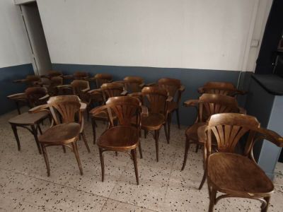 plusieurs chaises en bois dans une pièce au mur bleu