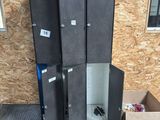 four black lockers sitting next to each other on the floor