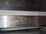 a close up of a microwave door with a metal handle