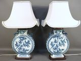 pair of blue and white vases with lamps on wooden bases