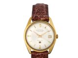 une montre-bracelet plaquée or, avec un cadran blanc et un bracelet en cuir marron