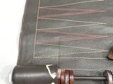 a leather bag with a pen and a pencil in it