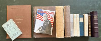 several books are lined up on a table with a green table cloth