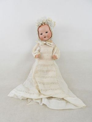 une image représentant une poupée en forme de bébé vêtue d'une robe blanche