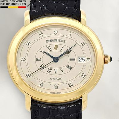 a gold wrist watch with a white dial and roman numerals