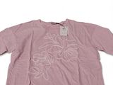 the shirt is pink and has white flowers on it