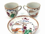 two cups and a saucer sitting on a plate