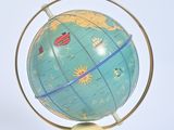 a blue and yellow globe on a stand on a white surface