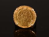 a gold sovereign coin on a black surface
