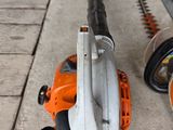 two chainsaws and a hedger on the ground