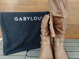 tan leather boots with gold buckles and a black bag