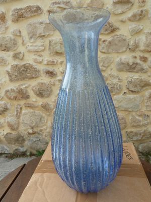a blue vase sitting on top of a box on a wooden table