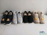 several pairs of tennis shoes lined up in a row on the floor
