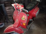 a red scooter that is parked in a garage