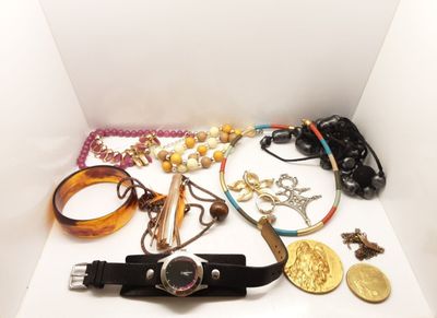 une boîte blanche remplie de bijoux variés, posée sur une table