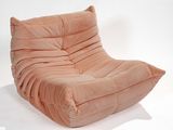 a pink chair that is sitting on a white surface