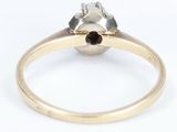 a close up of a gold ring with a black and white diamond