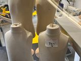 three mannequins sitting on a table in a room