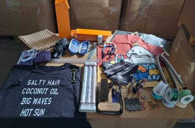 une table sur laquelle se trouvent de nombreux objets, notamment un chapeau, un t-shirt, des ciseaux et d'autres objets