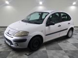 a picture of a small white car parked in a garage