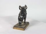 statue of a boar on a wooden base on a white surface