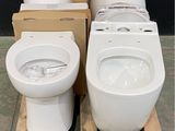 two toilets sitting on a pallet in a warehouse
