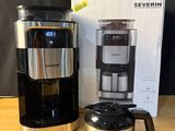 une cafetière noire et argentée posée sur une table en bois