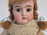 a close up of a doll on a white surface