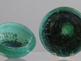 two green glass vases sitting on a clear table