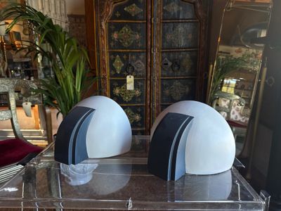 two white and black helmets sitting on top of a clear table
