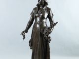 une statue antique en bronze représentant une femme tenant un panier de fleurs