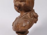 wooden bust of a woman on a pedestal with a white background