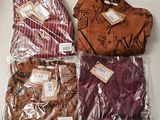 three men ' s shirts in plastic bags sitting on a table