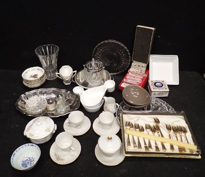 une table noire sur laquelle sont disposés de la vaisselle et des couverts argentés et blancs