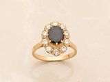 a gold ring with a black stone surrounded by white diamonds