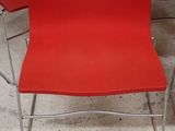 une chaise rouge qui se trouve au milieu d'une pièce