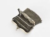 silver metal purse with chain around it on a white surface