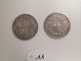 two silver coins sitting next to each other on top of a white surface