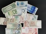Plusieurs billets de banque de différentes valeurs sont empilés sur une surface noire